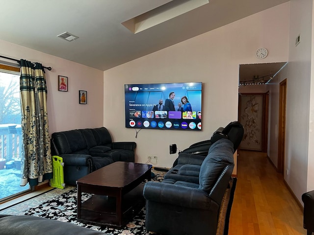 living room with lofted ceiling, wood finished floors, and visible vents