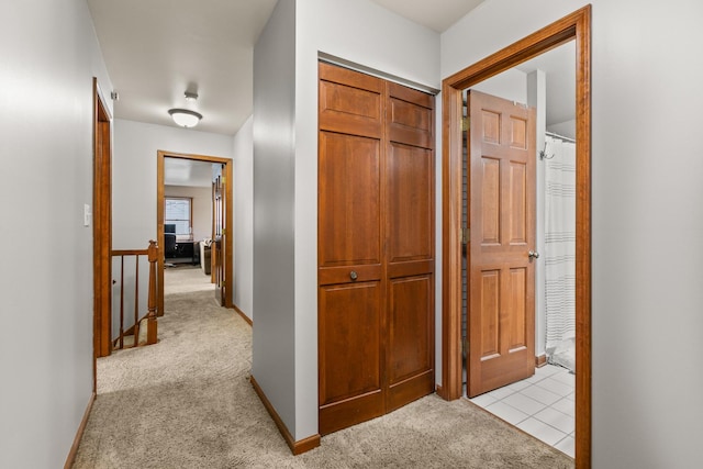 corridor with light colored carpet and baseboards