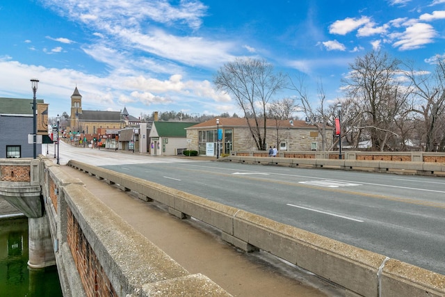 view of road featuring street lighting, curbs, and sidewalks