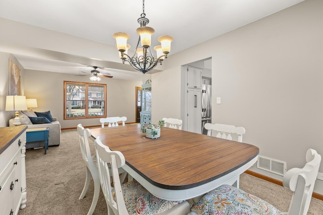 dining area with baseboards, ceiling fan with notable chandelier, visible vents, and light colored carpet