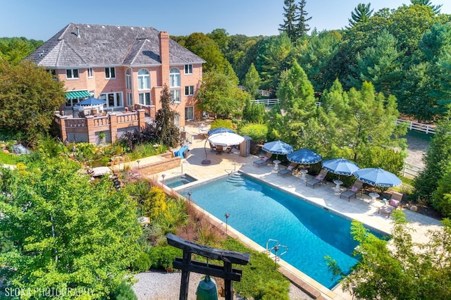 view of swimming pool featuring a wooden deck, a patio, and an in ground hot tub