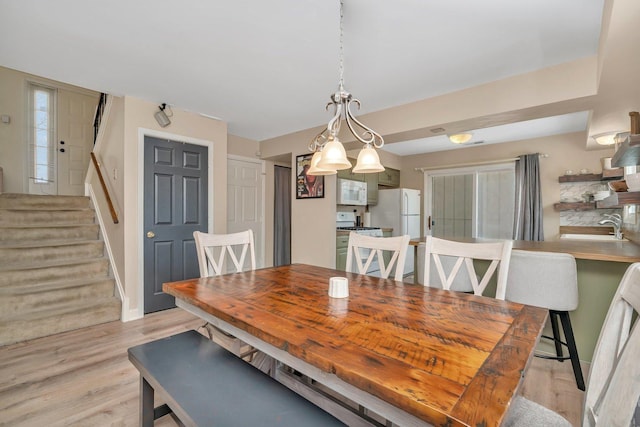 dining room with sink and light wood-type flooring