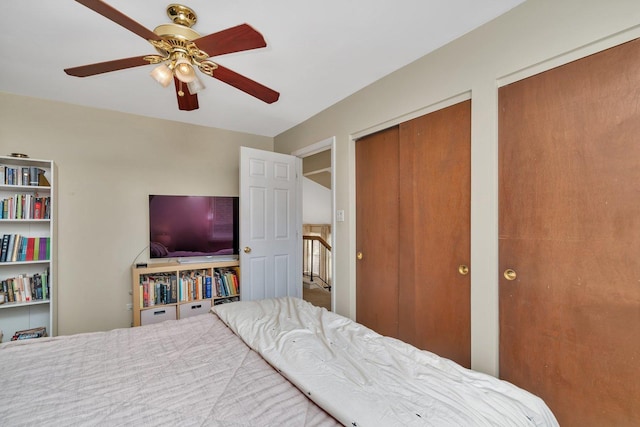 bedroom featuring ceiling fan and multiple closets