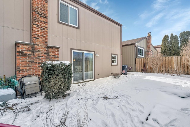 view of snow covered rear of property