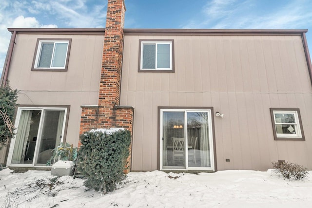 view of snow covered rear of property