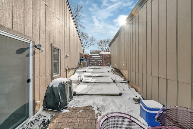 snow covered patio with a grill