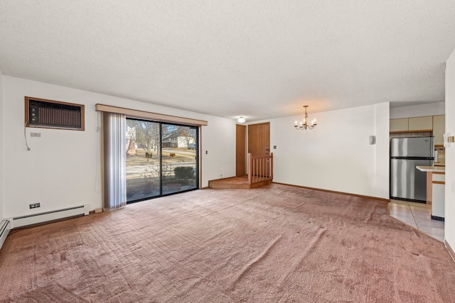 unfurnished living room featuring light carpet, a textured ceiling, a wall unit AC, baseboards, and a chandelier