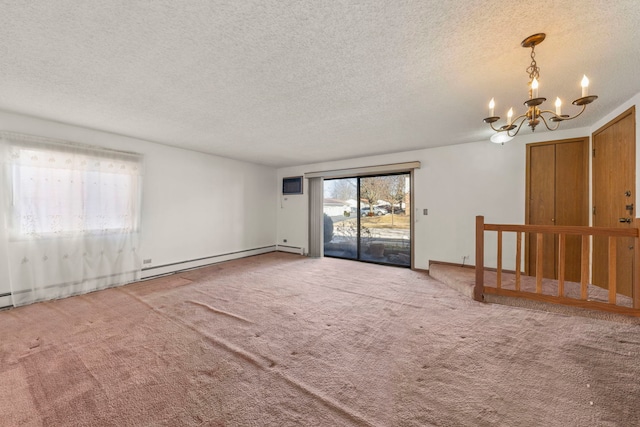 spare room with a baseboard heating unit, carpet floors, a textured ceiling, and an inviting chandelier