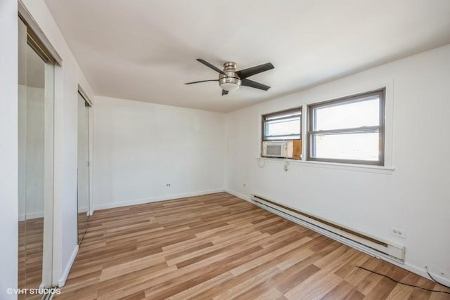 spare room with ceiling fan, cooling unit, baseboard heating, and light hardwood / wood-style floors