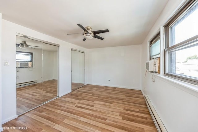 unfurnished bedroom with light hardwood / wood-style flooring, multiple closets, baseboard heating, cooling unit, and ceiling fan