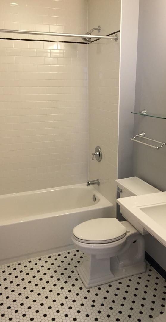 bathroom featuring toilet, tile patterned flooring, and shower / bathing tub combination