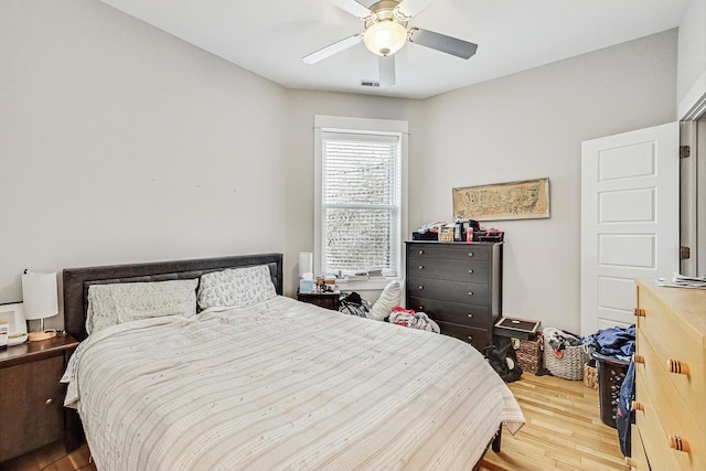 bedroom with visible vents, wood finished floors, and a ceiling fan