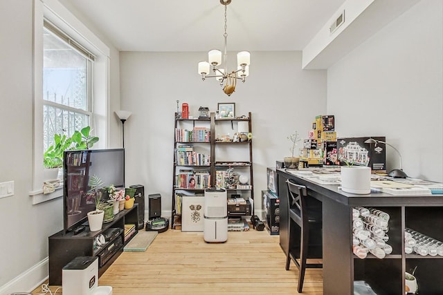 interior space with a notable chandelier, baseboards, visible vents, and wood finished floors