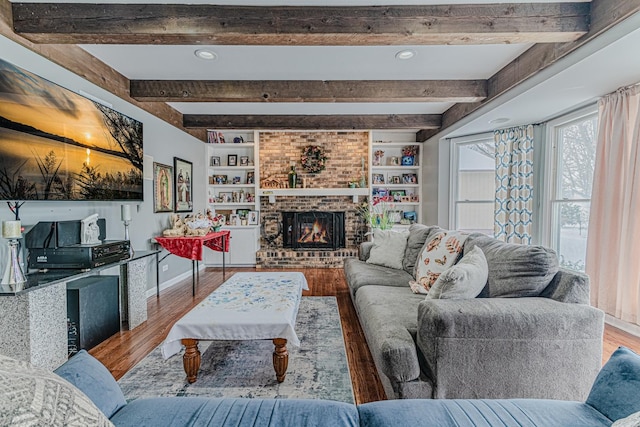 living room with wood-type flooring, built in features, and a fireplace