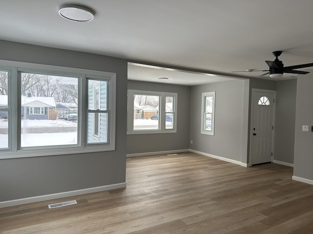 entryway featuring a ceiling fan, light wood-style flooring, visible vents, and baseboards