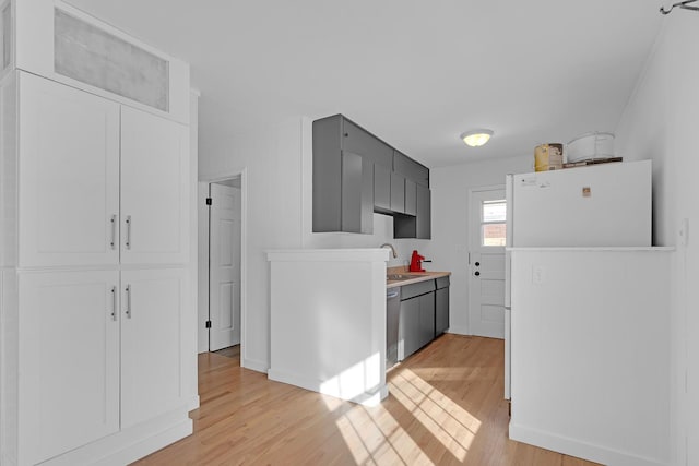 kitchen featuring sink, light hardwood / wood-style flooring, dishwasher, and white refrigerator