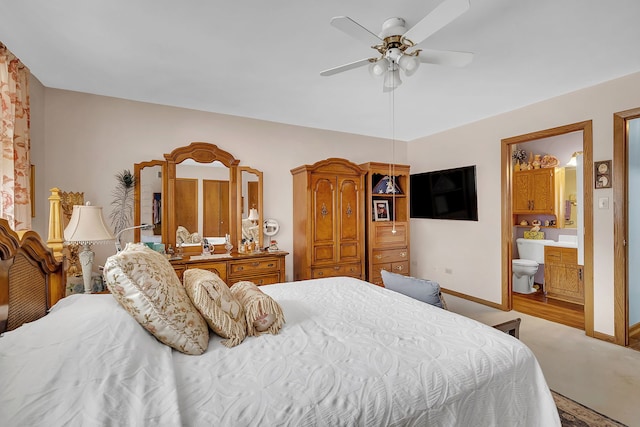 bedroom with hardwood / wood-style flooring, ensuite bathroom, and ceiling fan