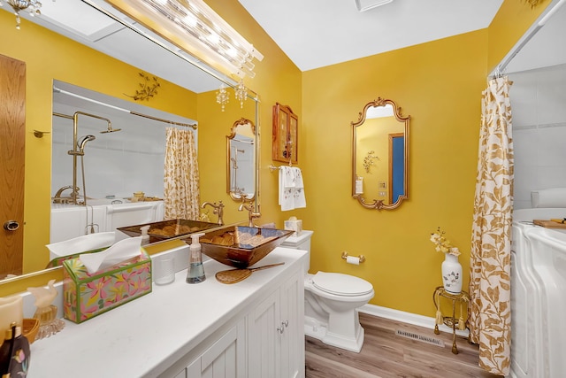 bathroom with hardwood / wood-style floors, toilet, and a shower with shower curtain