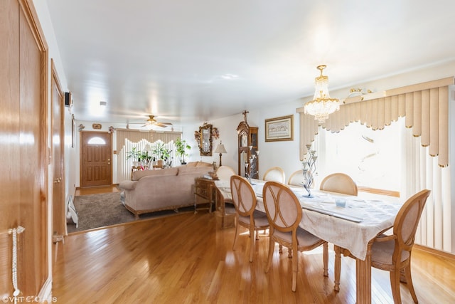 dining area featuring ceiling fan with notable chandelier and light hardwood / wood-style flooring