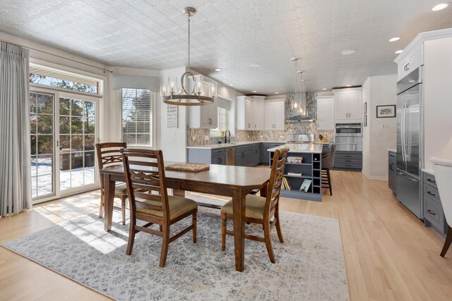 dining space with an inviting chandelier, light wood-style flooring, and recessed lighting