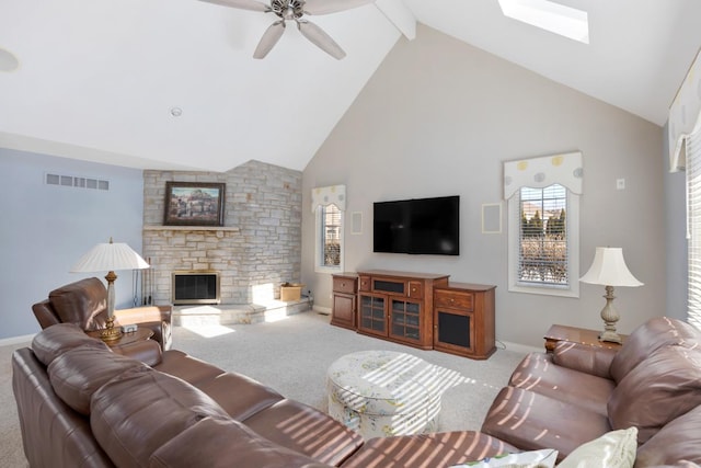 carpeted living room with visible vents, ceiling fan, a stone fireplace, high vaulted ceiling, and beam ceiling