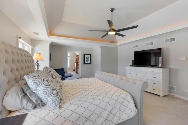 bedroom featuring light carpet, a raised ceiling, and visible vents