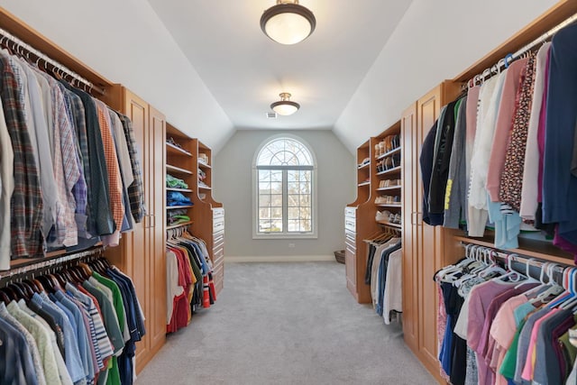 walk in closet featuring vaulted ceiling and light colored carpet