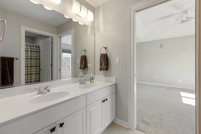 full bath featuring a ceiling fan, a sink, baseboards, and double vanity