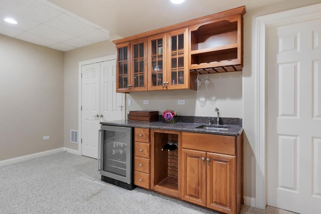 bar featuring wine cooler, visible vents, a sink, wet bar, and baseboards