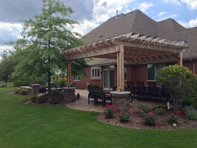 rear view of house with a patio area, a yard, brick siding, and a pergola