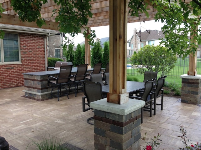 view of patio featuring fence, outdoor dry bar, and outdoor dining space