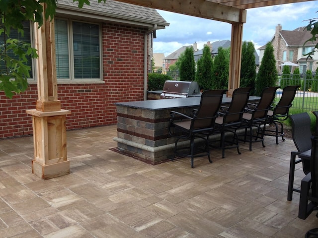 view of patio / terrace with grilling area, an outdoor kitchen, fence, a pergola, and outdoor wet bar