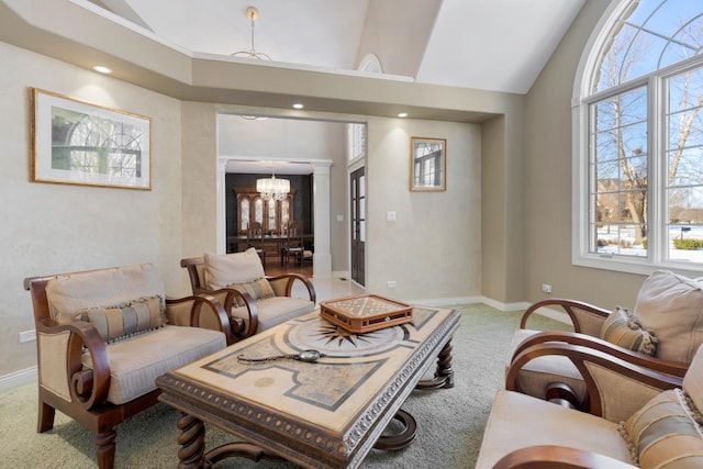 carpeted living room featuring a healthy amount of sunlight, baseboards, vaulted ceiling, and a notable chandelier