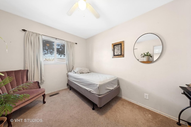 bedroom with baseboards, a ceiling fan, visible vents, and light colored carpet