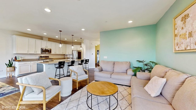 living area featuring light wood-style flooring, baseboards, and recessed lighting