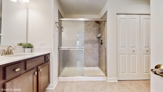 full bathroom with a shower stall, tile patterned floors, vanity, and a closet