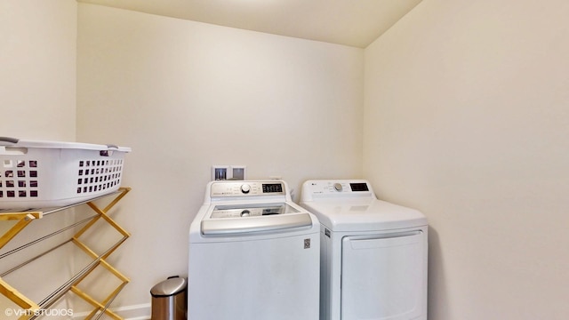 clothes washing area with independent washer and dryer and laundry area