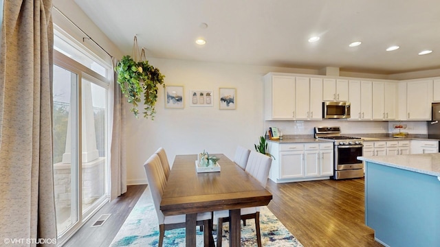 kitchen featuring visible vents, white cabinetry, wood finished floors, and appliances with stainless steel finishes