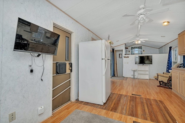 kitchen with light wood-type flooring, vaulted ceiling, a ceiling fan, and freestanding refrigerator