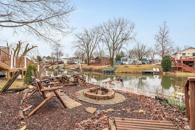 view of yard with stairway, a residential view, a fire pit, and a deck with water view