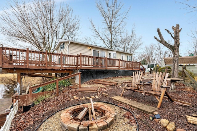 back of house featuring a fire pit and a deck