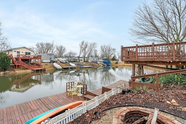 view of dock featuring an outdoor fire pit and a deck with water view