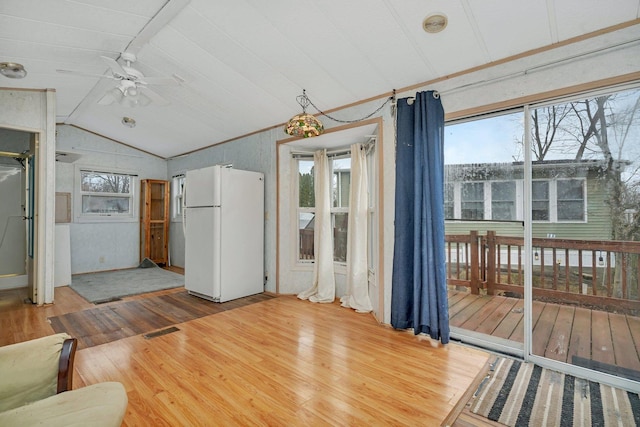 living room with vaulted ceiling, wood finished floors, visible vents, and a healthy amount of sunlight