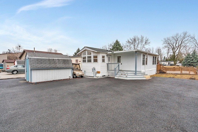 manufactured / mobile home featuring fence and an outbuilding