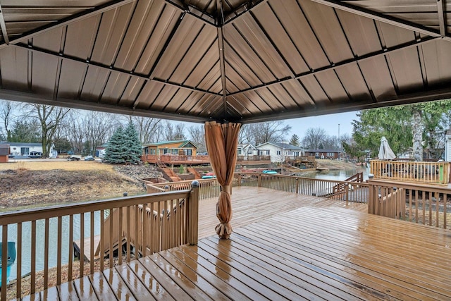 wooden terrace featuring a water view and a gazebo