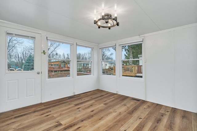 unfurnished sunroom with visible vents and an inviting chandelier