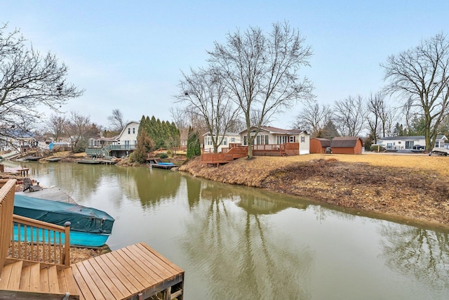 view of dock with a deck with water view and a residential view