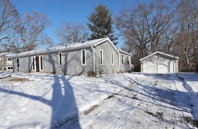 view of snow covered exterior with a garage and an outdoor structure