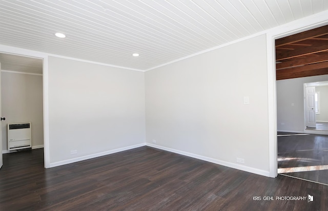 unfurnished room featuring ornamental molding, dark wood-type flooring, heating unit, and wooden ceiling