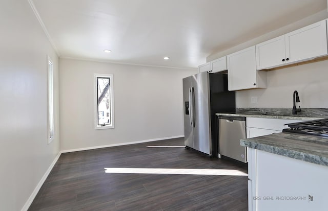 kitchen with white cabinetry, appliances with stainless steel finishes, ornamental molding, and dark hardwood / wood-style flooring